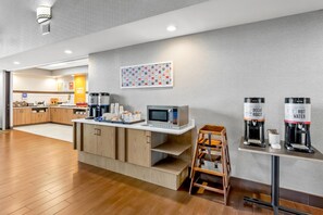 A modern kitchen area with a microwave, coffee machines, and a coffee station. - Hampton Inn & Suites Scottsburg (Scottsburg)