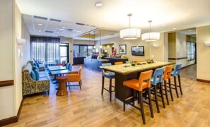 Un vestíbulo de hotel con comedor, cocina y bar.