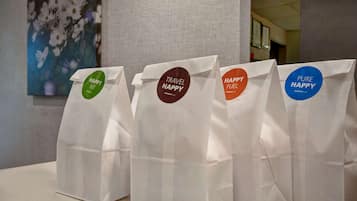 Cuatro bolsas de papel blancas con etiquetas de colores distintos sobre una mesa.