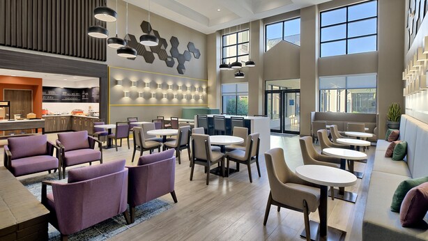 A spacious lobby with multiple seating areas, including sofas and tables. There are large windows providing natural light and views of the outdoors. - Hampton Inn & Suites Houston-Cypress Station (Houston)