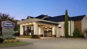 A Hampton Inn & Suites by Hilton with a modern design, featuring a covered entrance and a welcoming sign. - Hampton Inn & Suites Houston-Cypress Station (Houston)