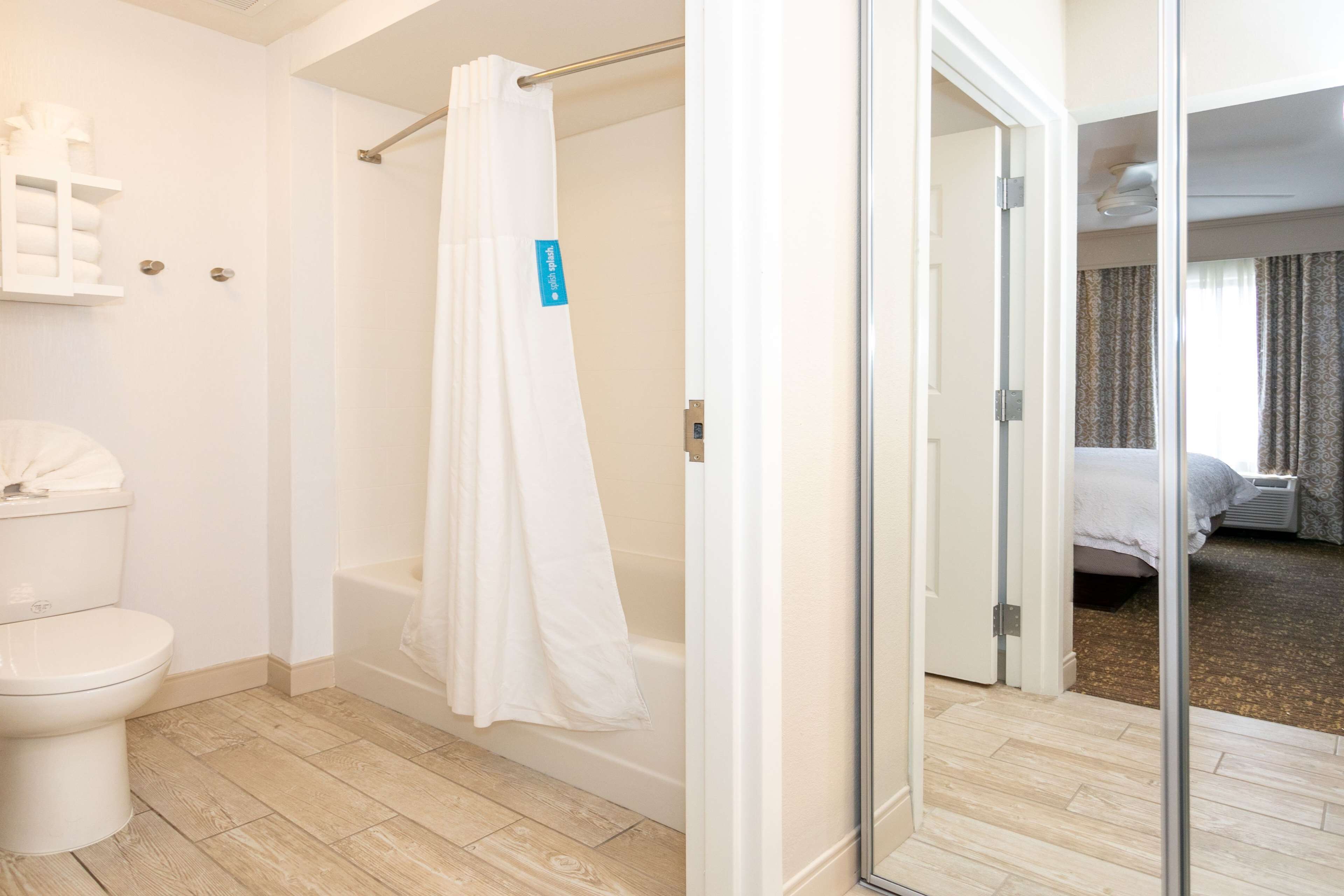 A modern bathroom with a toilet, shower, and bathtub.