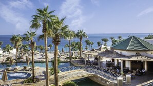 A resort with a pool, palm trees, and a bridge. - Park Regency Sharm El Sheikh Resort (Sharm El Sheikh)