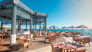 An outdoor dining area with wooden tables and chairs, a decorative gazebo, and umbrellas providing shade. - Park Regency Sharm El Sheikh Resort (Sharm El Sheikh)