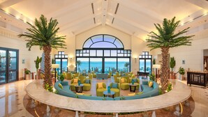 A spacious lobby with a curved marble floor, seating areas with green and blue sofas, and two palm trees. - Park Regency Sharm El Sheikh Resort (Sharm El Sheikh)