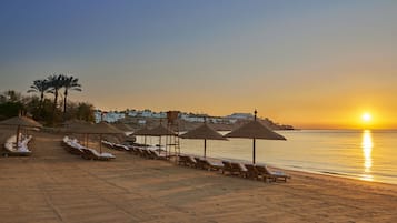 Na praia, barracas de praia de cortesia, espreguiçadeiras, guarda-sóis