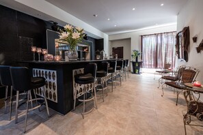 A modern kitchen with a central island, bar stools, and a dining area with wicker chairs.