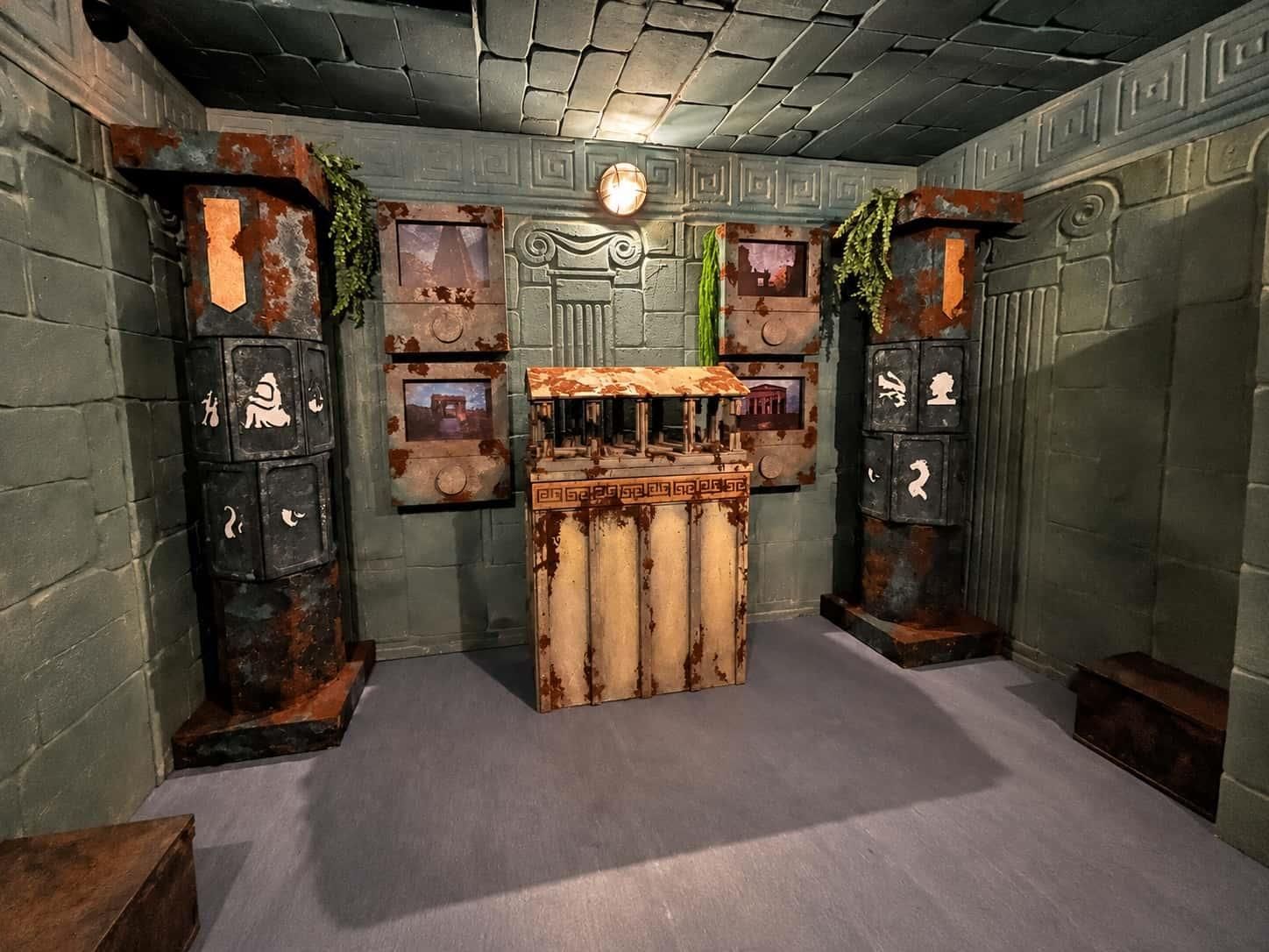A room with a central table, two side cabinets, and a decorative wall with a clock.