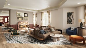 A modern living room with a fireplace, sofas, a coffee table, and a blue armchair. - InterContinental Suites Hotel Cleveland by IHG (Cleveland)