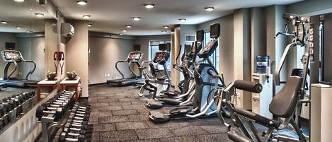 A gym with treadmills, elliptical machines, and weight equipment.