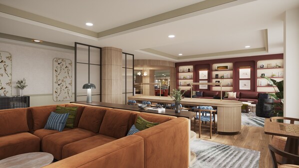 A modern living room with a brown sofa, a dining area with a bar, and a kitchen in the background. - InterContinental Suites Hotel Cleveland by IHG (Cleveland)