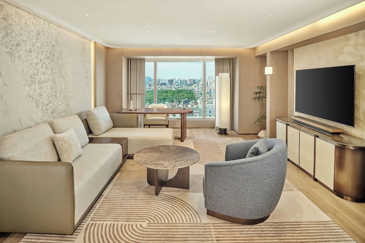 Un salon moderne comprenant un canapé, un fauteuil, une table basse et un téléviseur.