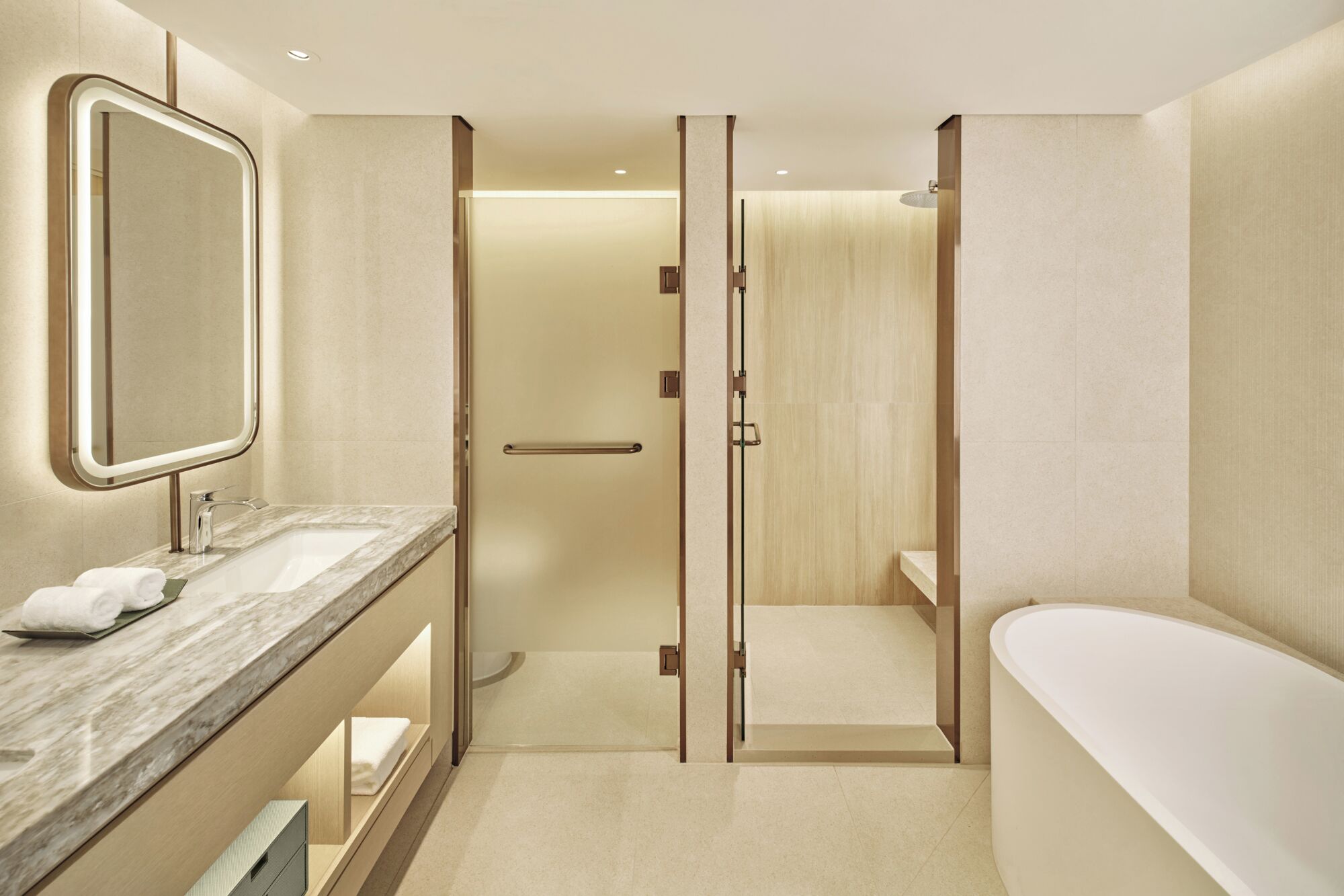 A modern bathroom with a marble sink, a large mirror, a walk-in shower, and a freestanding bathtub.