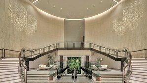 A spacious lobby with a central staircase, a glass railing, and a seating area with modern chairs. - The Westin Seoul Parnas (Seoul)