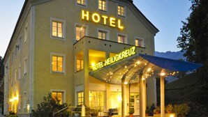 Un hôtel avec une enseigne bien visible indiquant « HÔTEL » et le mot « HEILIGKREUZ » écrit en dessous.