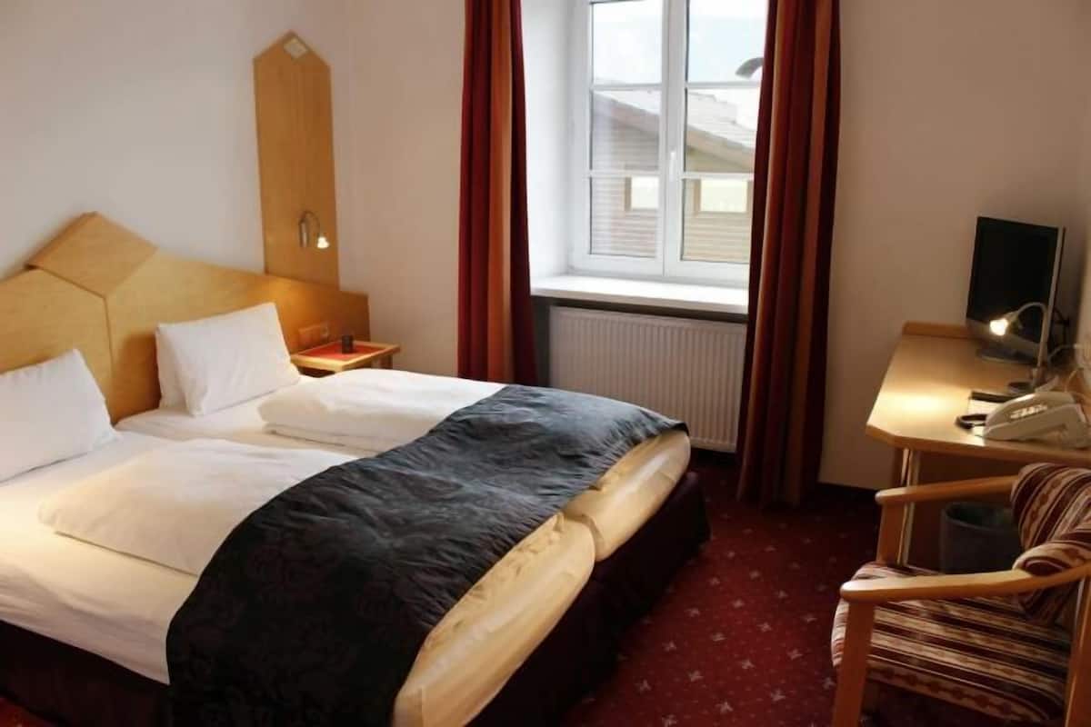 Luxe beddengoed, een kluis op de kamer, een bureau, een laptopwerkplek