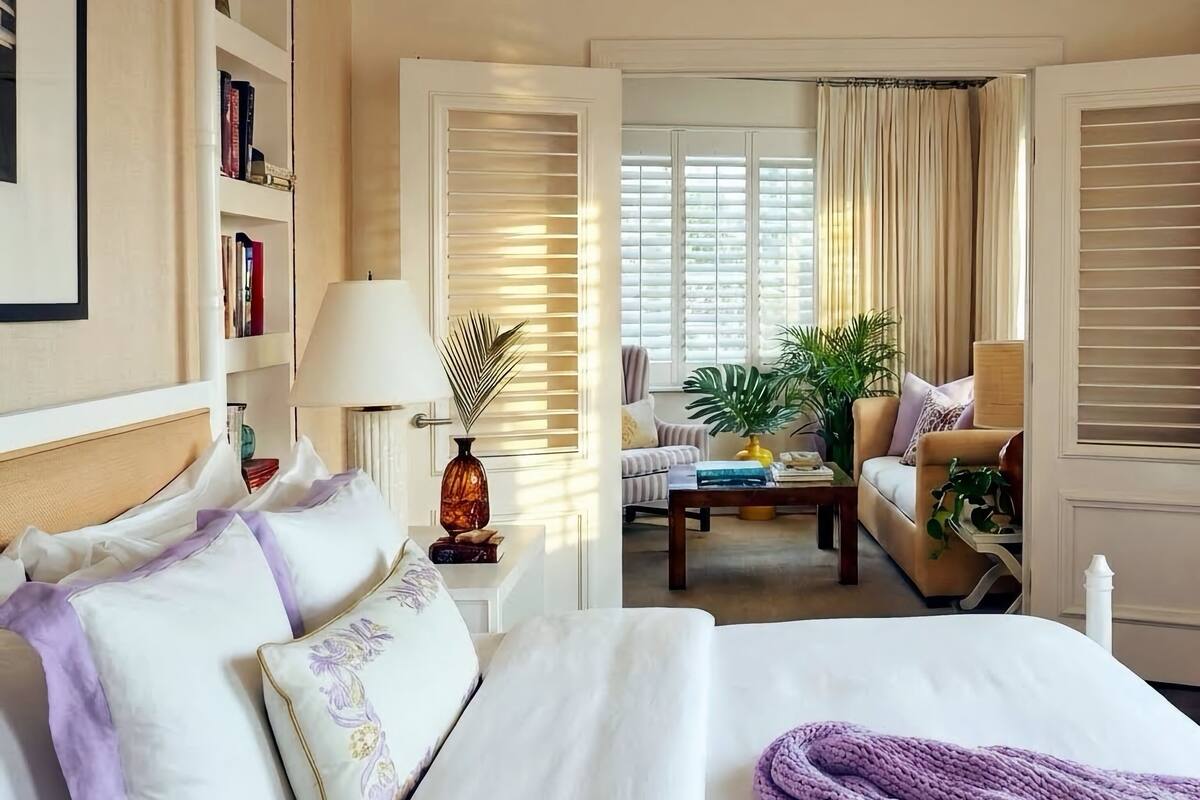 Ein Hotelzimmer mit einem Bett, einem Sofa, einem Couchtisch und einem Bücherregal.