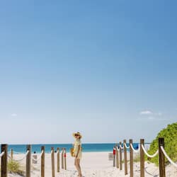 On the beach, white sand, beach cabanas, sun loungers