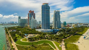 A coastal cityscape with high-rise buildings, a beach, and a park.