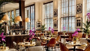 A spacious hotel lobby with multiple seating areas, a bar, and large windows. - The Betsy - South Beach (Miami Beach)