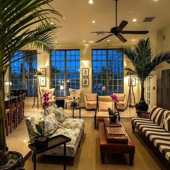 A spacious living room with a striped sofa, a coffee table, and a piano. at The Betsy - South Beach