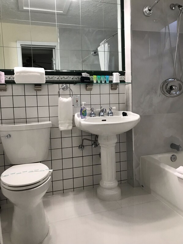 A bathroom with a toilet, sink, and shower. - Cherokee Lodge (Coronado)