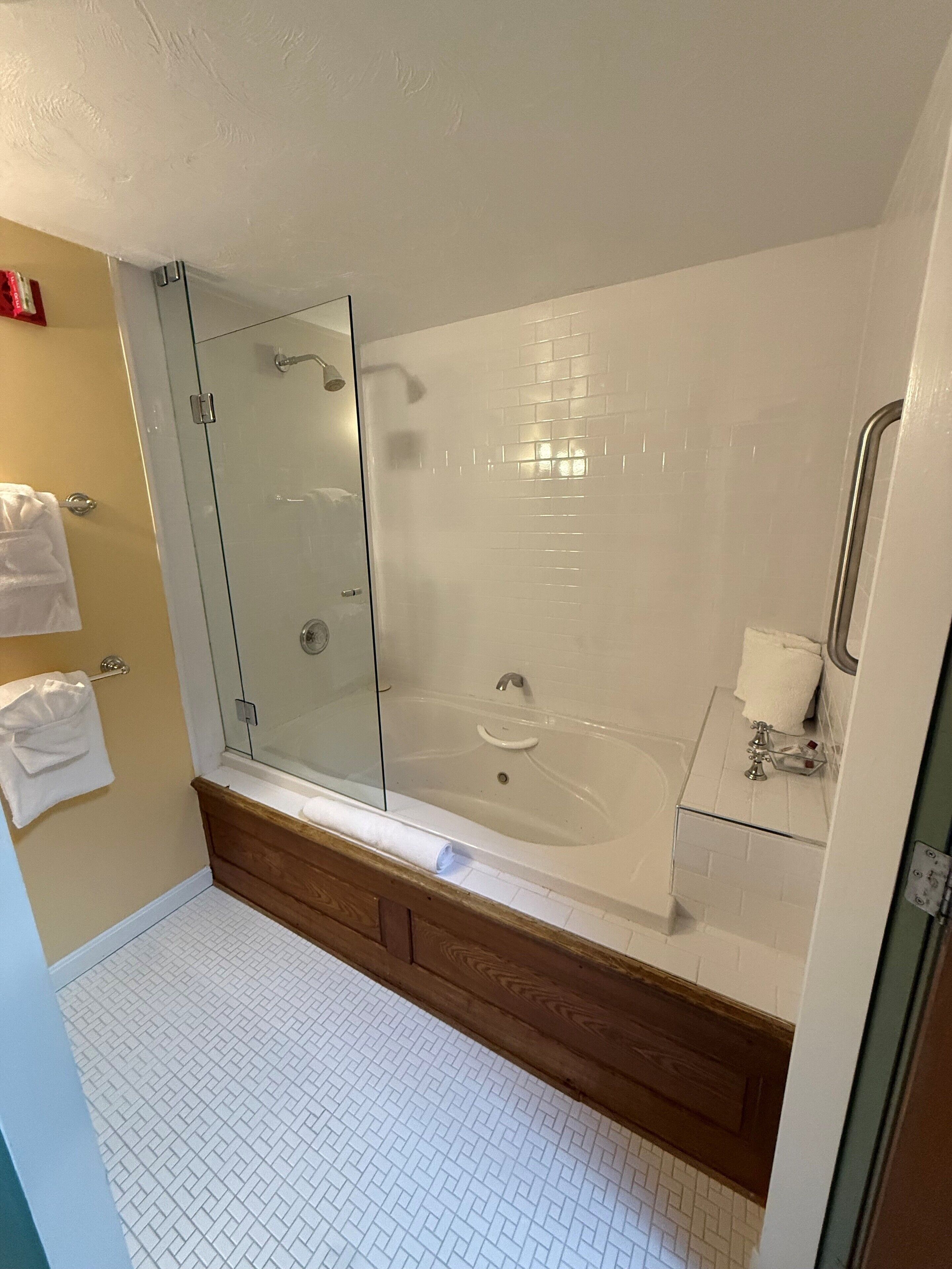 Une salle de bain moderne avec une douche à parois de verre, une baignoire sur pieds et un meuble-lavabo en bois.