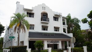 Un bâtiment blanc avec une enseigne indiquant « Offres spéciales à l’hôtel ! » et un numéro de téléphone.