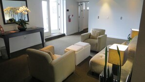 Un hall d’entrée moderne avec un comptoir d’accueil, un espace salon et une grande fenêtre.