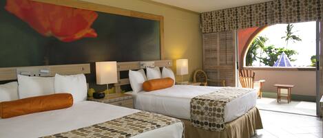 A hotel room with two beds, a ceiling fan, a large painting, and a view of palm trees through a window.