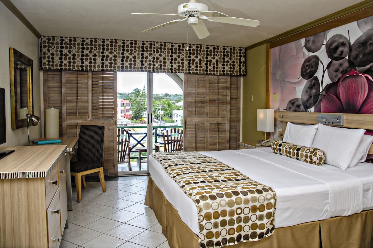 Ein Hotelzimmer mit Bett, Schreibtisch, Stuhl und Blick ins Freie.