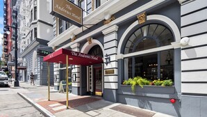 Das Andrews Hotel mit einer klassischen Fassade, einem roten Markisenbalkon und einer Blumenauslage im Schaufenster.