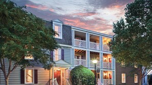 A multi-story building with a balcony on the second floor, a covered front porch, and a brick facade. - Club Wyndham Kingsgate (Williamsburg)