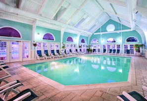 An indoor swimming pool with multiple lounge chairs and arched doorways. - Club Wyndham Kingsgate (Williamsburg)