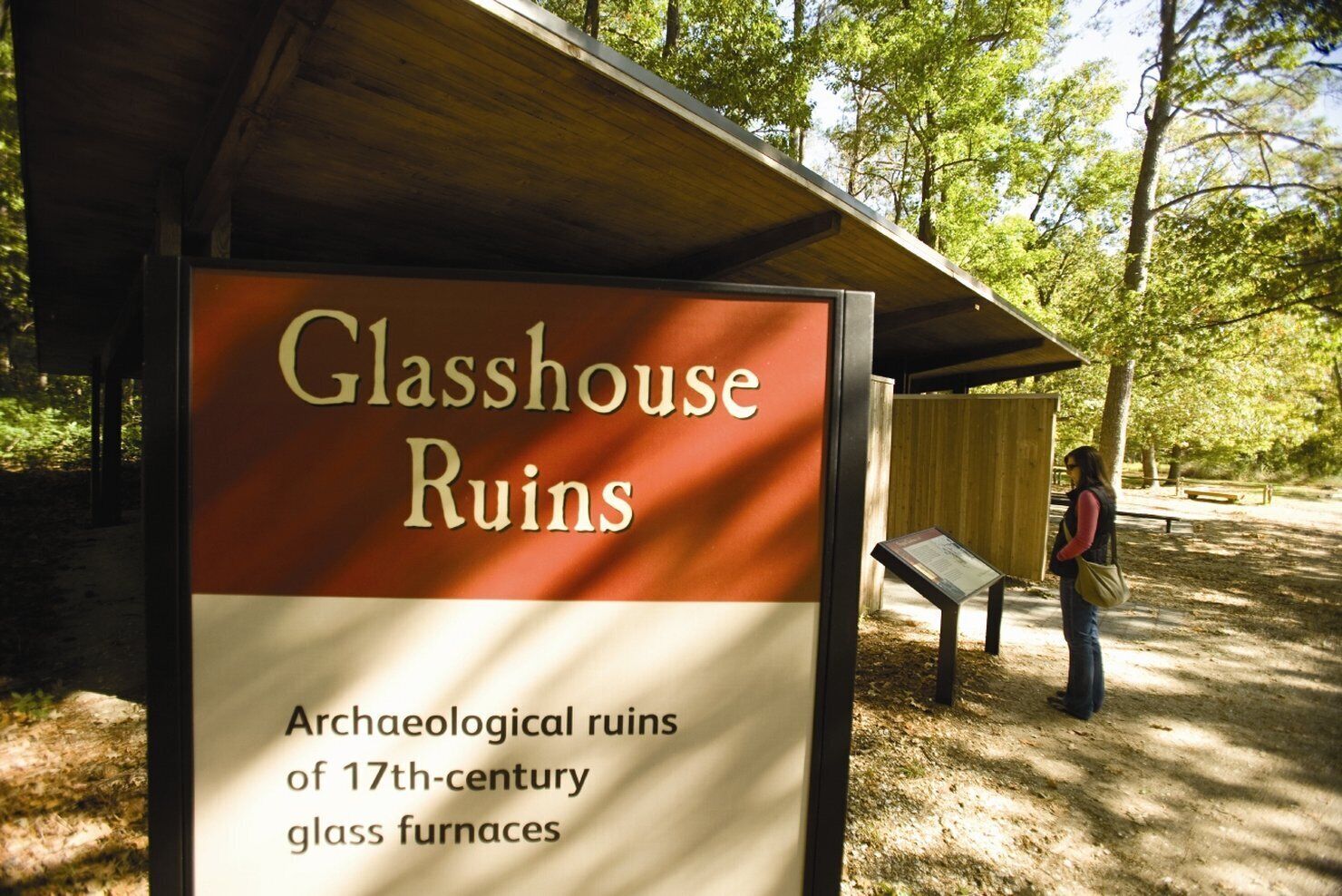 A sign for Glasshouse Ruins, indicating archaeological ruins of 17th-century glass furnaces.