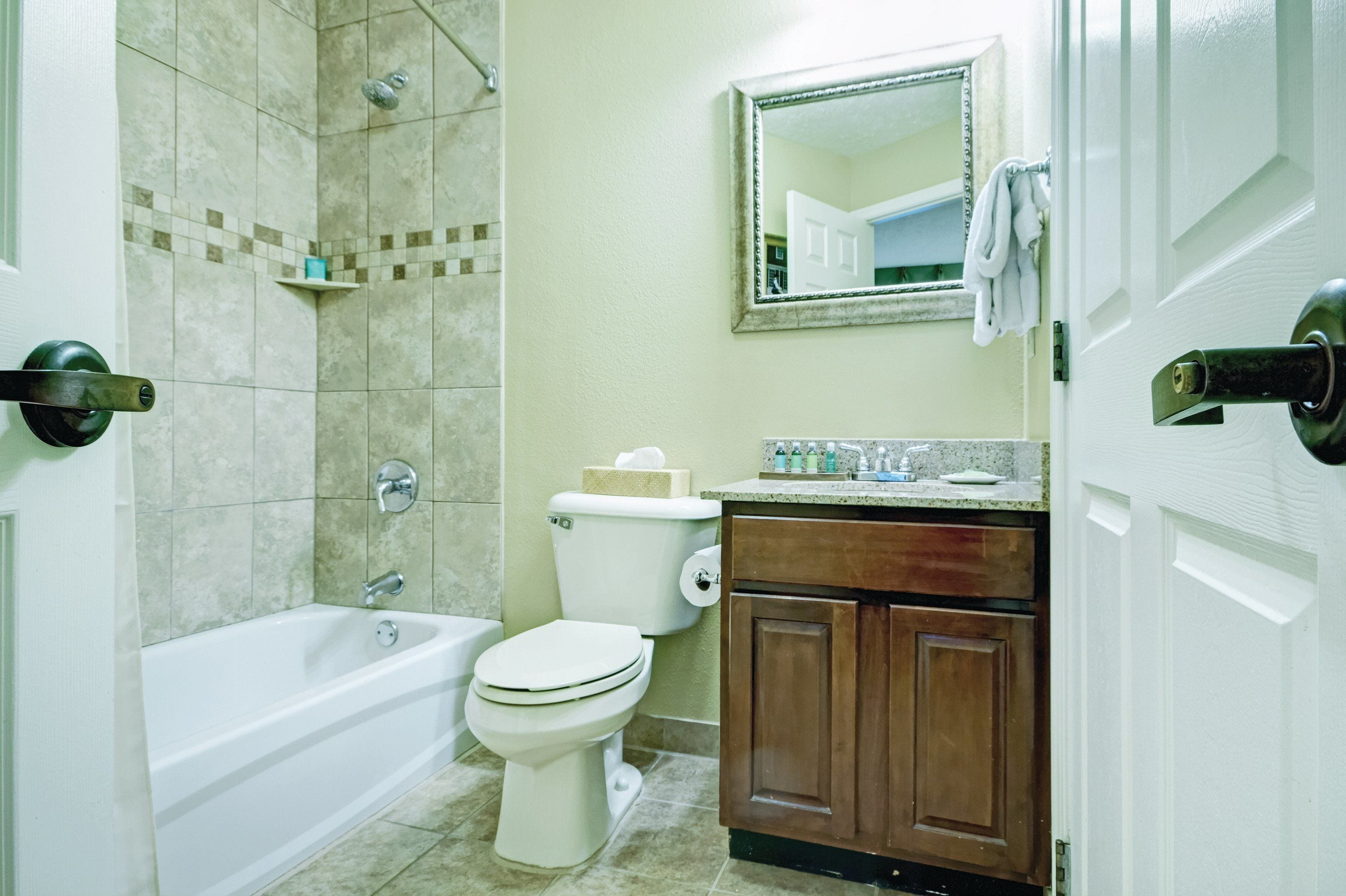 A bathroom with a bathtub, toilet, and vanity.