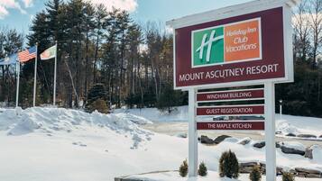 A sign for Mount Ascutney Resort with a Holiday Inn Club Vacations logo, indicating guest registration and The Maple Kitchen.