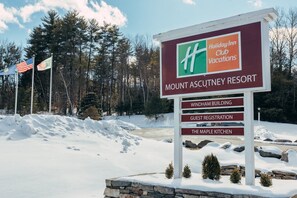 A sign for Mount Ascutney Resort with directions to the Wyndham Building, Guest Registration, and The Maple Kitchen.