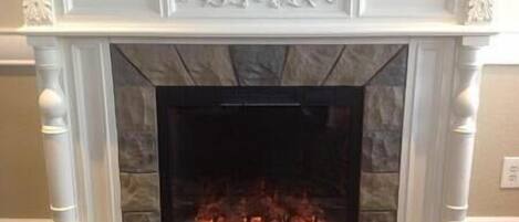 A fireplace with a stone surround and decorative moldings.