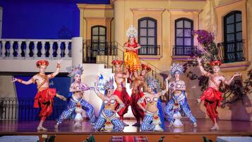 A stage with dancers in colorful costumes performing a traditional dance.