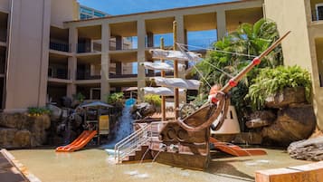 Explore a pirate-themed play area with a ship structure, slides, and a small waterfall, surrounded by a pool.