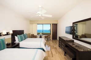 A hotel room with two beds, a desk, a chair, a television, and a large window with a view. - El Cid Castilla Beach Hotel (Mazatlán)