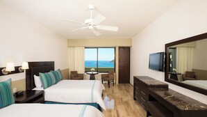 A hotel room with two beds, a desk, a chair, a television, and a large window with a view. - El Cid Castilla Beach Hotel (Mazatlán)