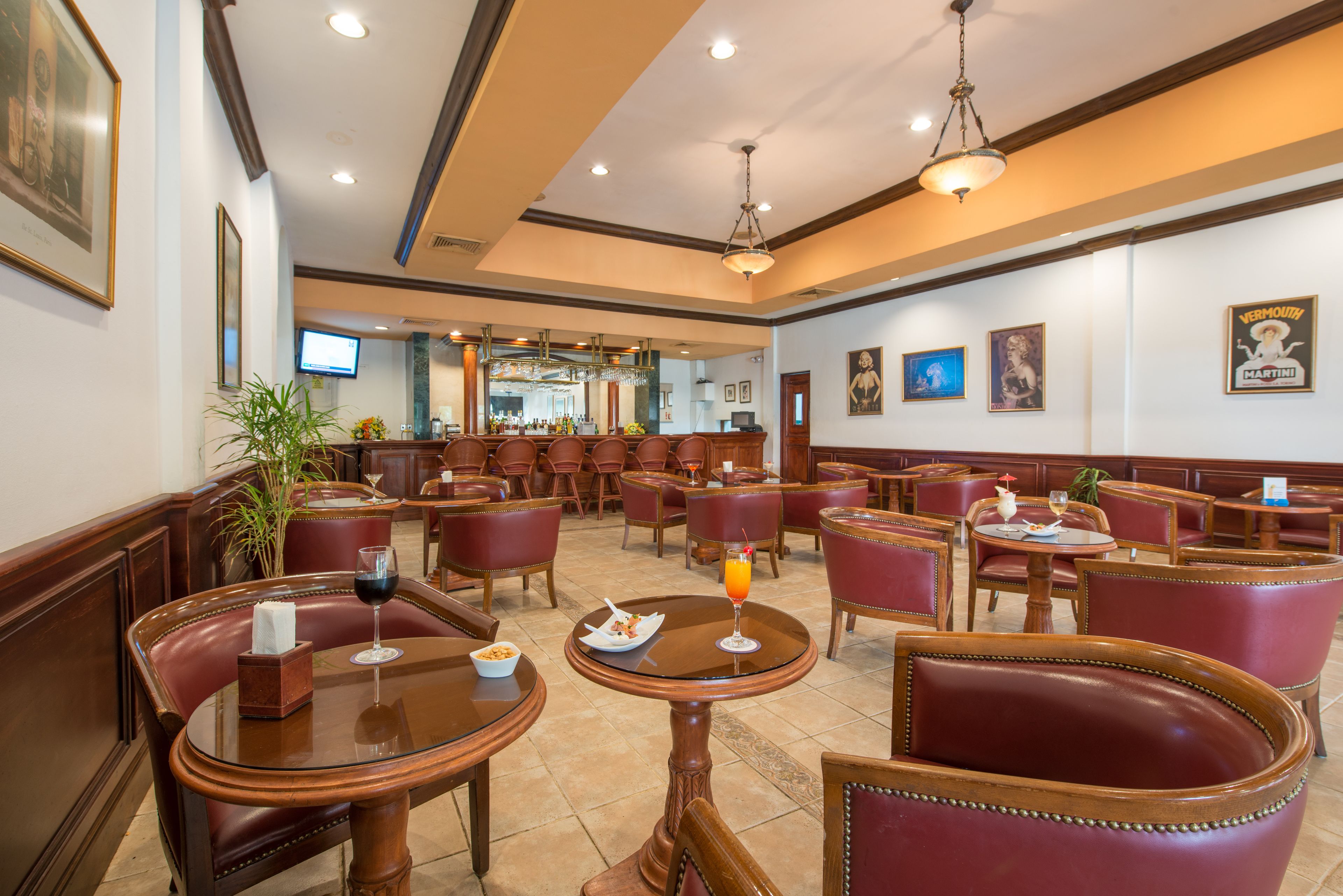 Un restaurant doté de nombreuses tables et de banquettes, d’un bar et d’un écran de télévision placé à l’arrière.