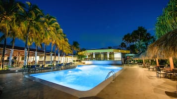 Una piscina al aire libre, sillones reclinables de piscina