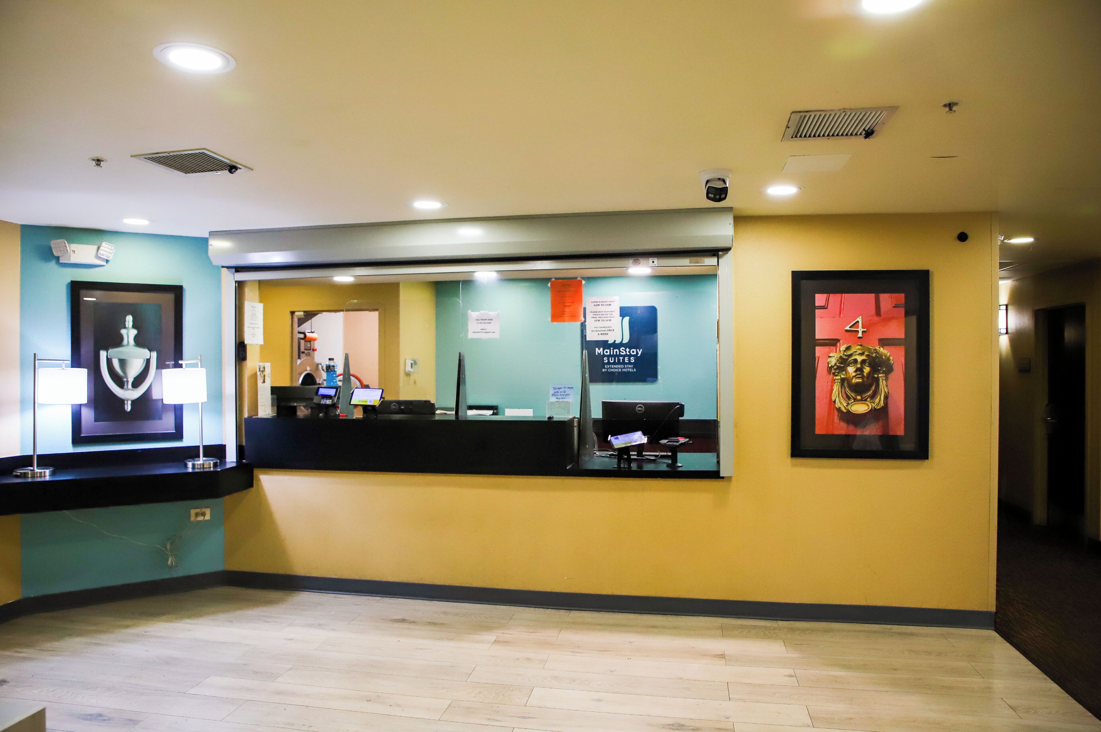A reception area with a counter, a computer, and a sign indicating MainStay Suites.