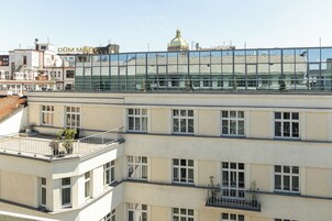Um edifício com várias andares e fachada de vidro que reflete a arquitetura ao redor.