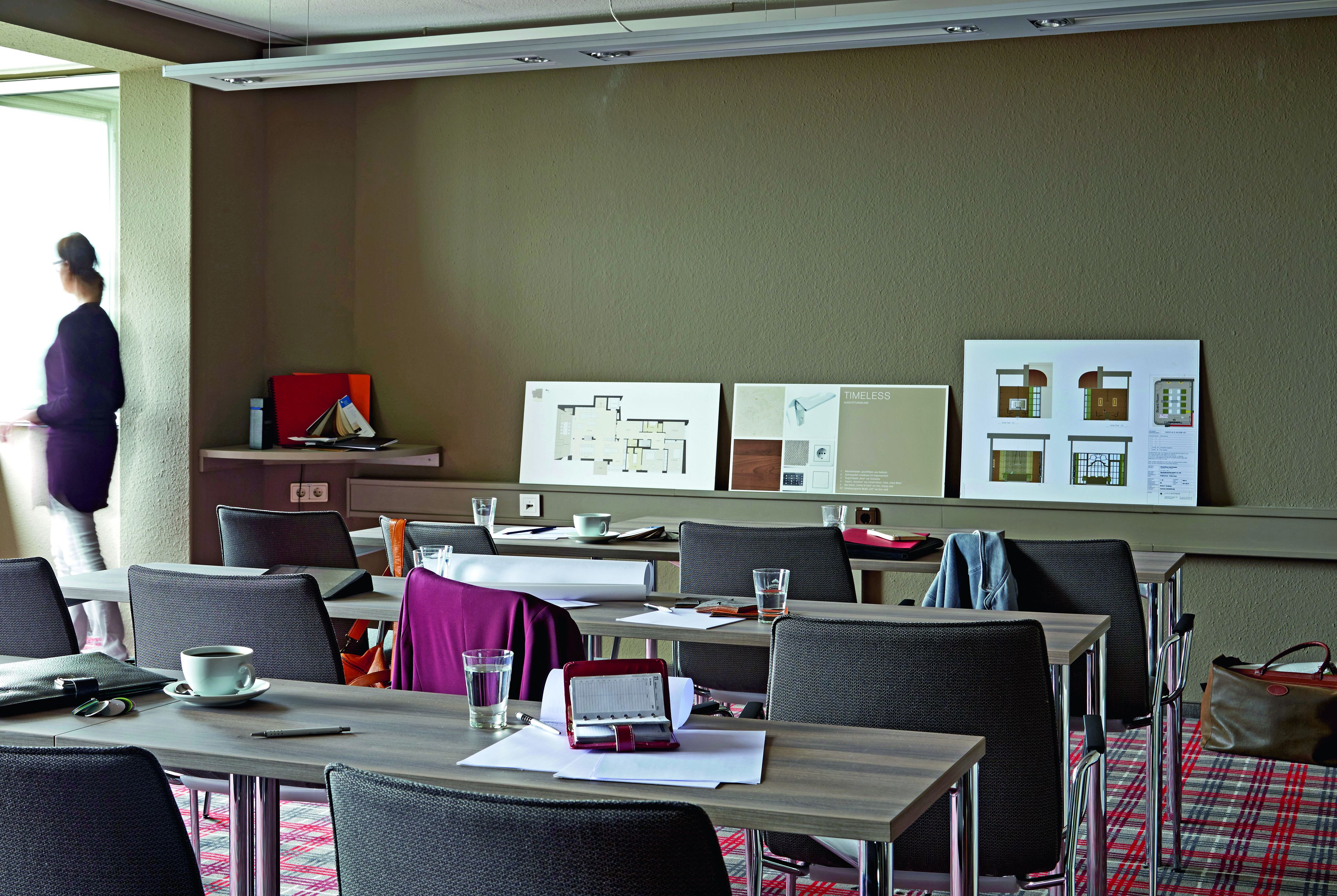 A conference room with tables, chairs, and presentation boards.