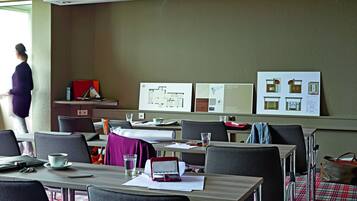 A conference room with tables, chairs, and presentation boards.
