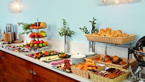 A buffet with various food items and a three-tiered fruit display. - Seaside Residenz Hotel Chemnitz (Chemnitz)